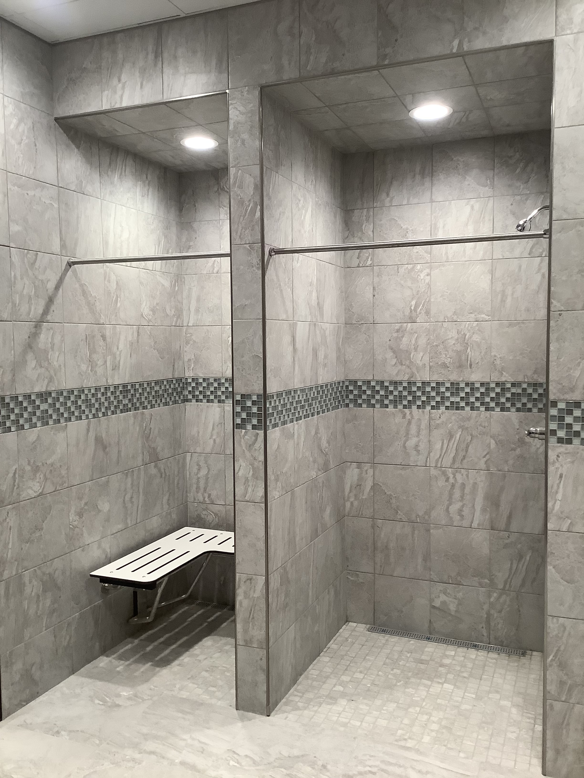 Commercial tiled shower with bench and grab bars