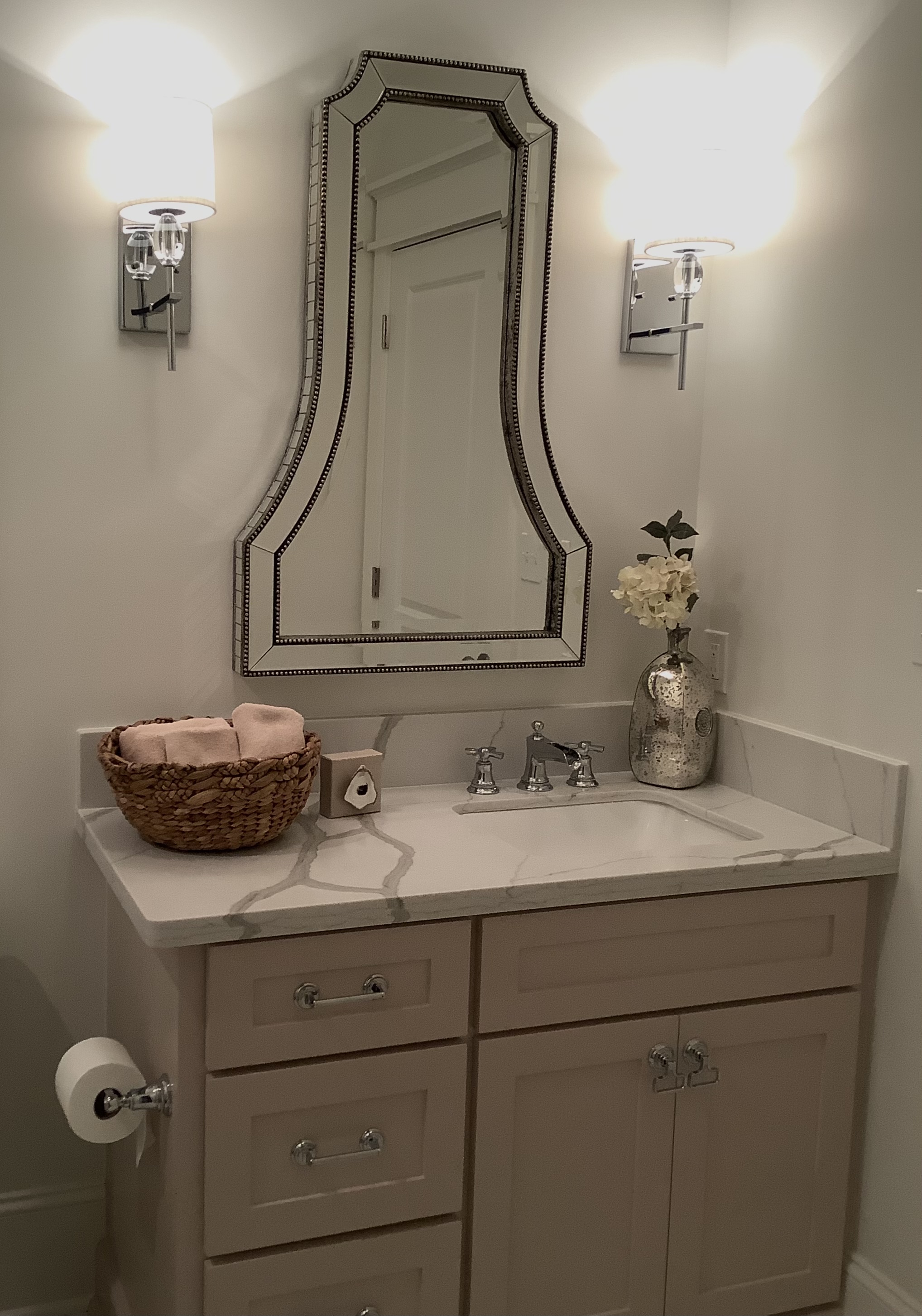 Chic bathroom with ornate mirror and elegant lighting