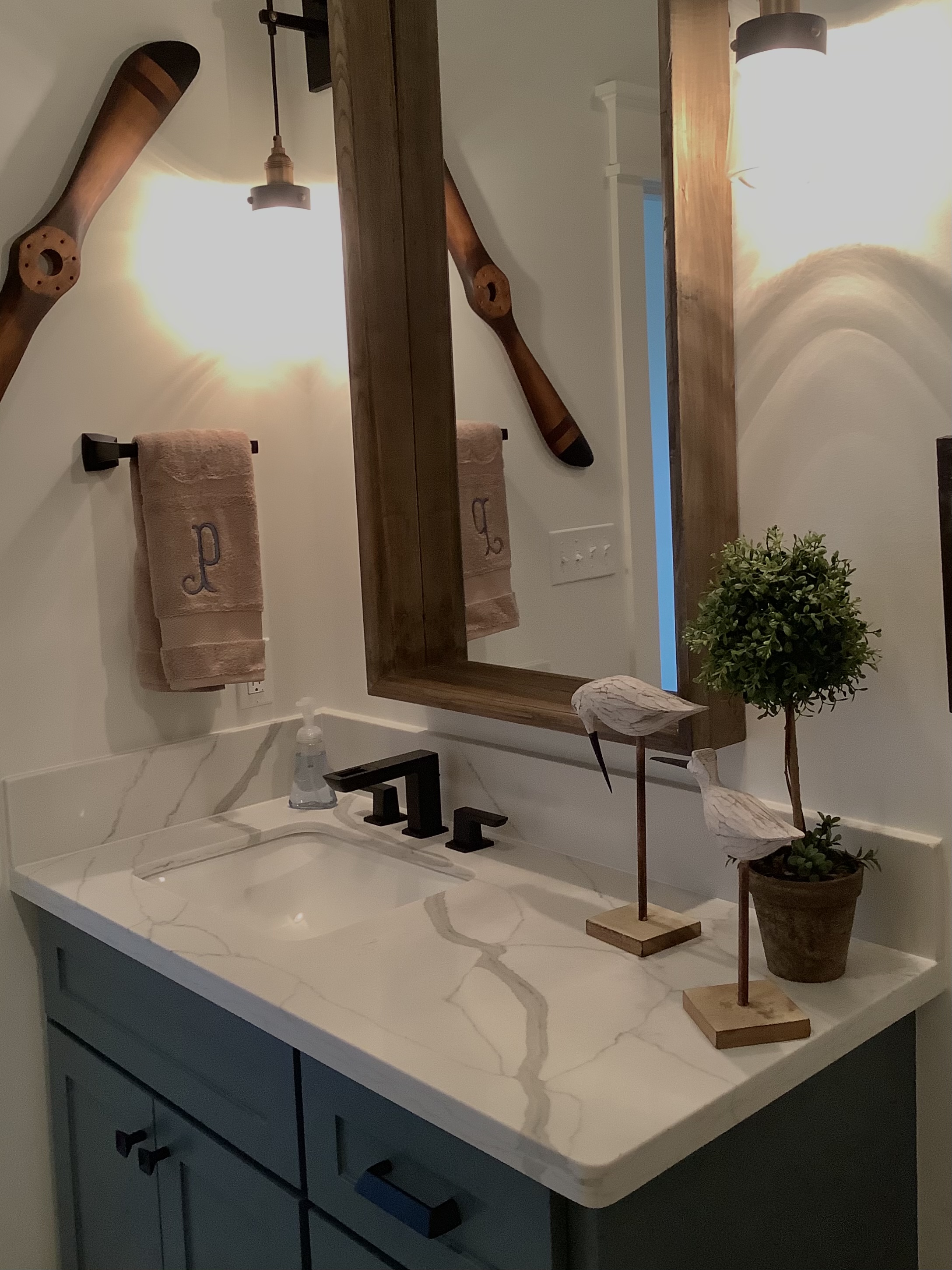 Bathroom with wooden mirror frame and black fixtures