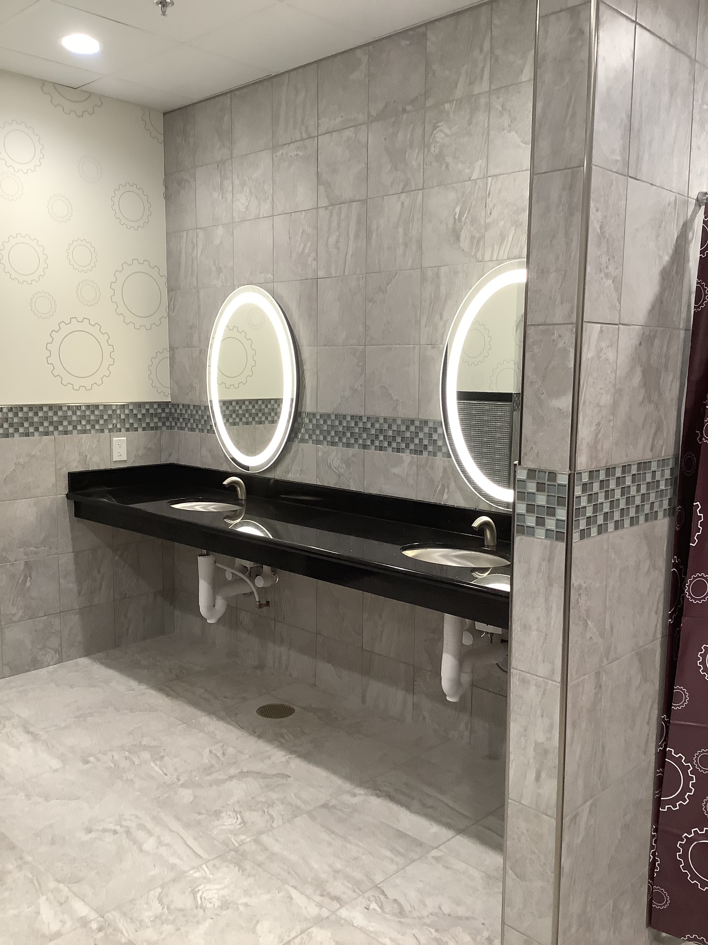 Commercial restroom with backlit mirrors and sleek surfaces