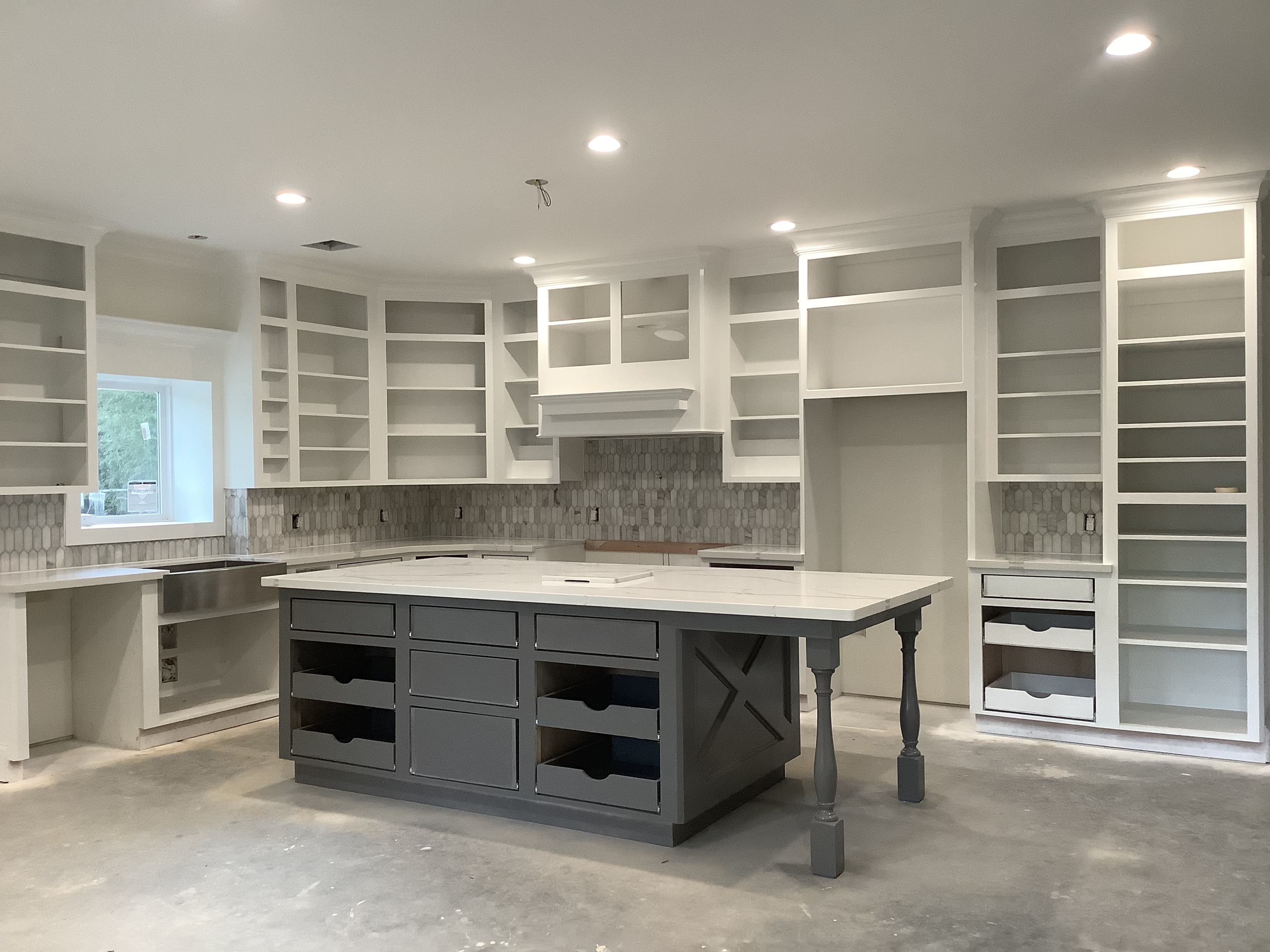 Modern kitchen under construction with central island and open shelving