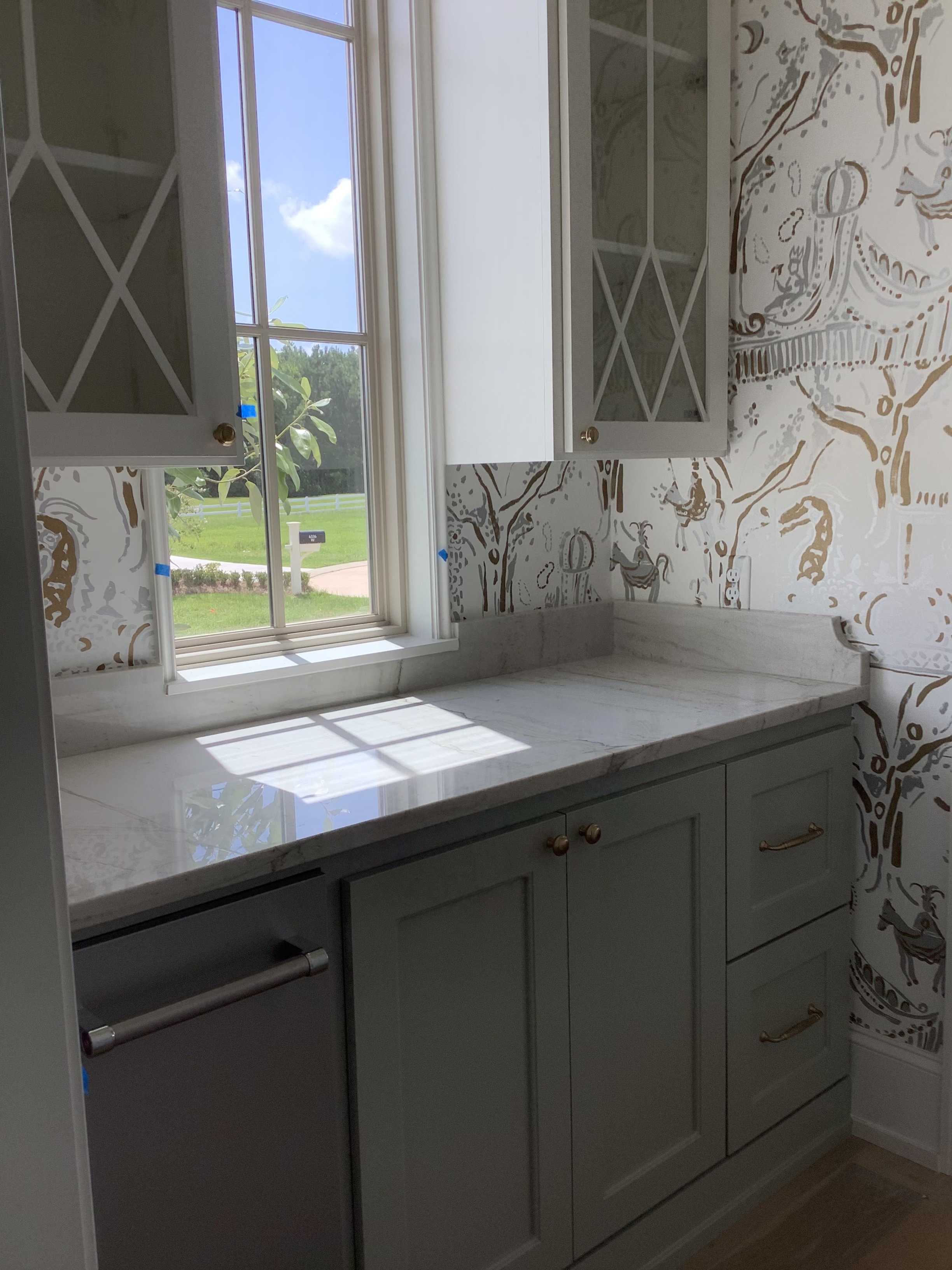 Pantry nook with wallpaper, window, and upper cabinets